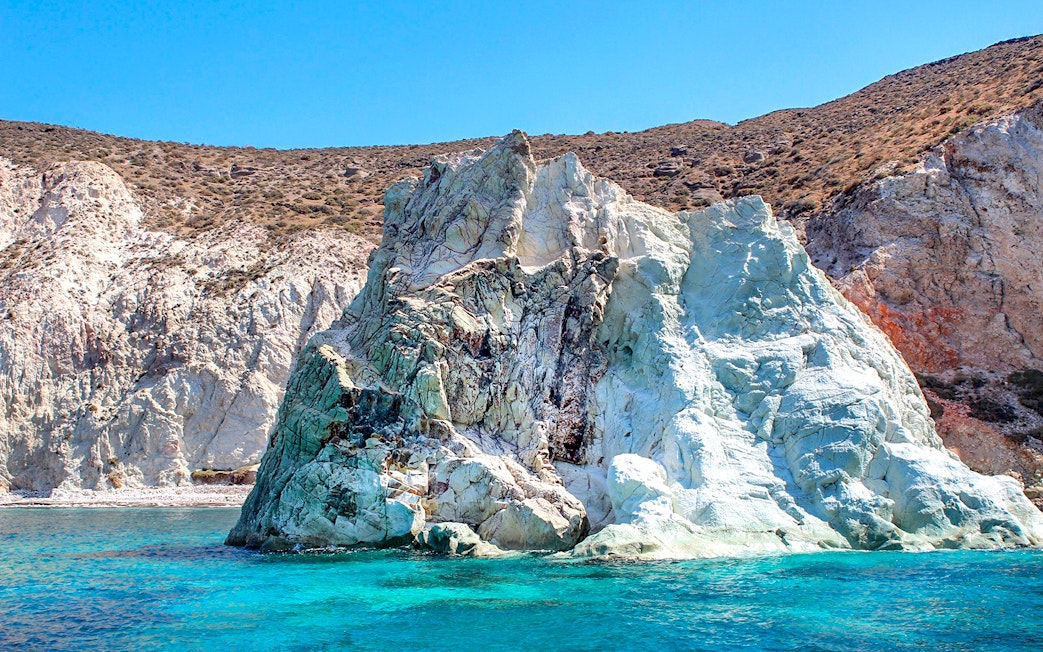Rocky coastline with turquoise waters on Santorini Luxury Catamaran Cruise.