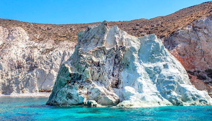 Rocky coastline with turquoise waters on Santorini Luxury Catamaran Cruise.