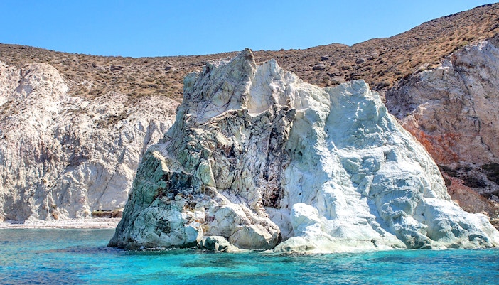 Rocky coastline with turquoise waters on Santorini Luxury Catamaran Cruise.