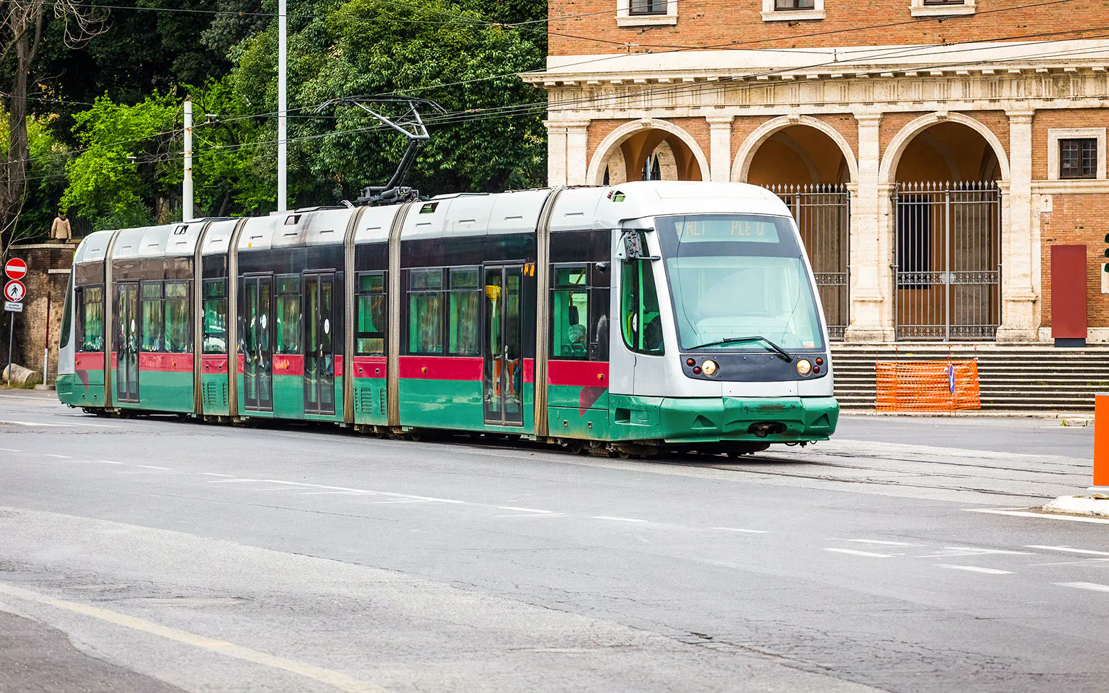 Tram passing by historic building in Rome, Italy.