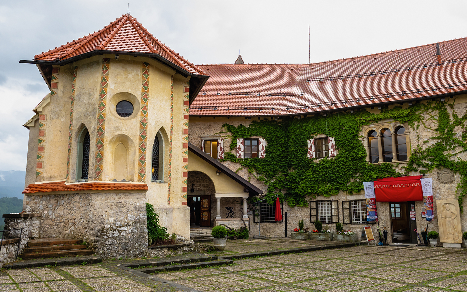 Inner courtyard of Bled Castle in Slovenia with ivy-covered walls and historic architecture.