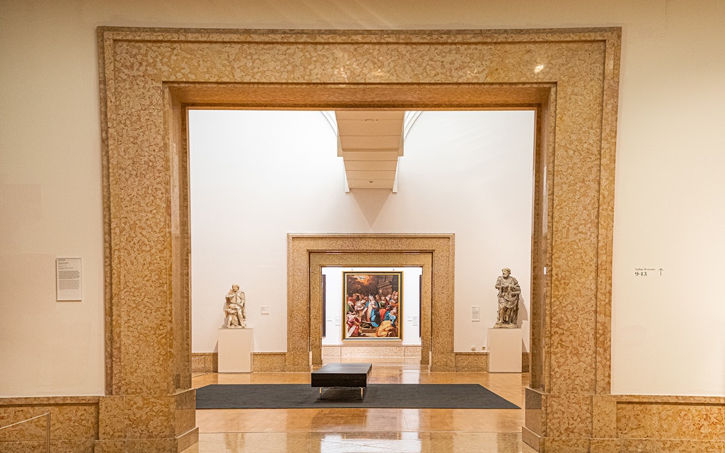 Interior view of National Museum of Ancient Art with sculptures and framed painting.