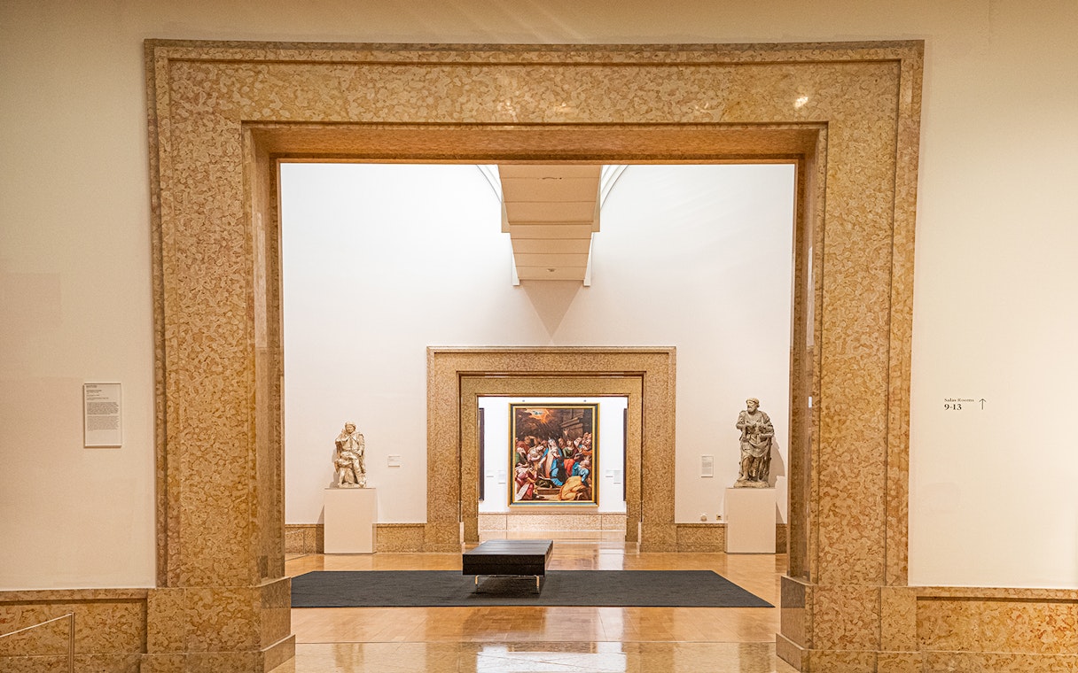 Interior view of National Museum of Ancient Art with sculptures and framed painting.