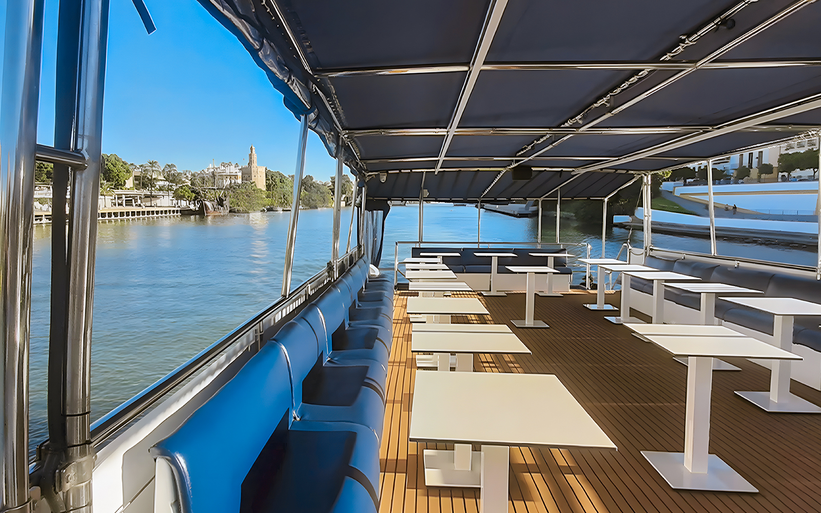 Sitting area on Seville Guadalquivir River sightseeing cruise with view of Torre del Oro.