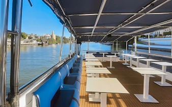 Sitting area on Seville Guadalquivir River sightseeing cruise with view of Torre del Oro.