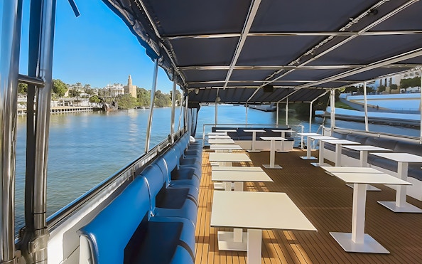 Sitting area on Seville Guadalquivir River sightseeing cruise with view of Torre del Oro.
