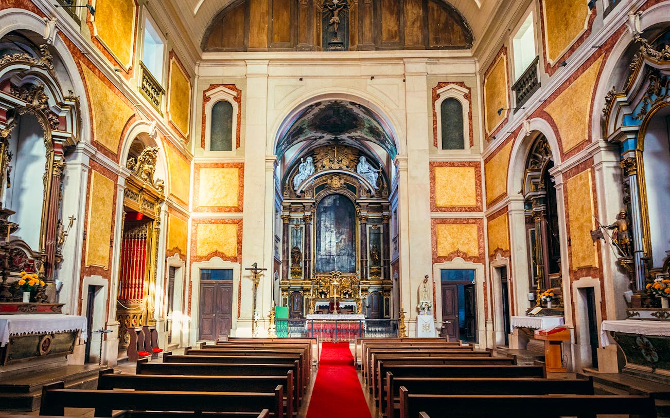 Interior of St George's Castle Church with ornate altar and pews, Lisbon, Portugal.