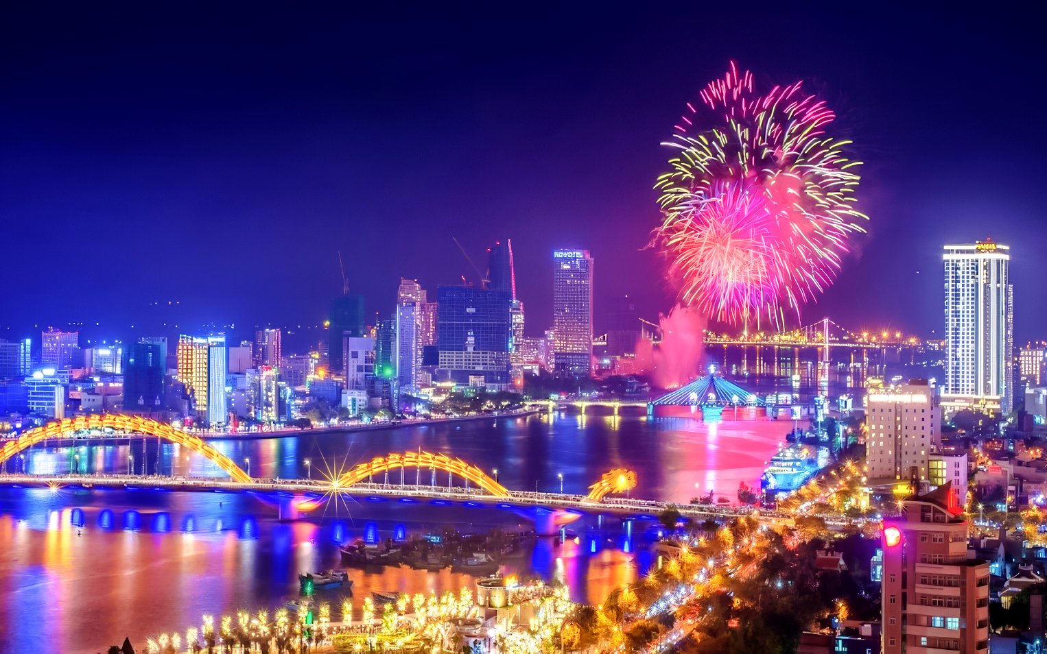Fireworks over Da Nang skyline with Dragon Bridge and city lights.