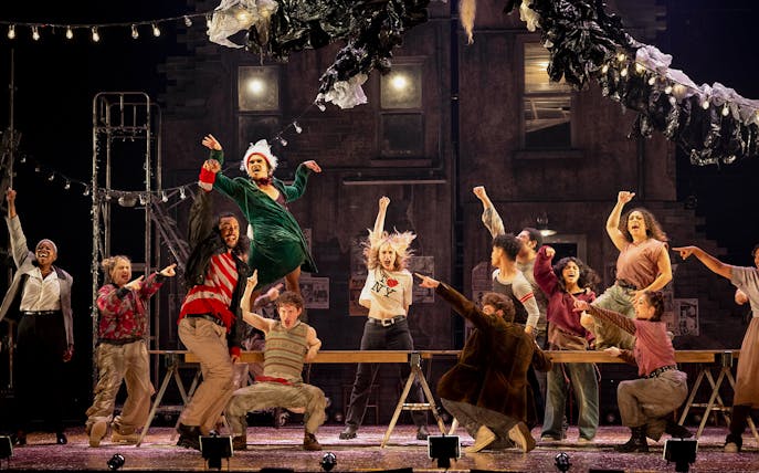 Performers on stage during a lively scene from the musical "Rent" in New York City.