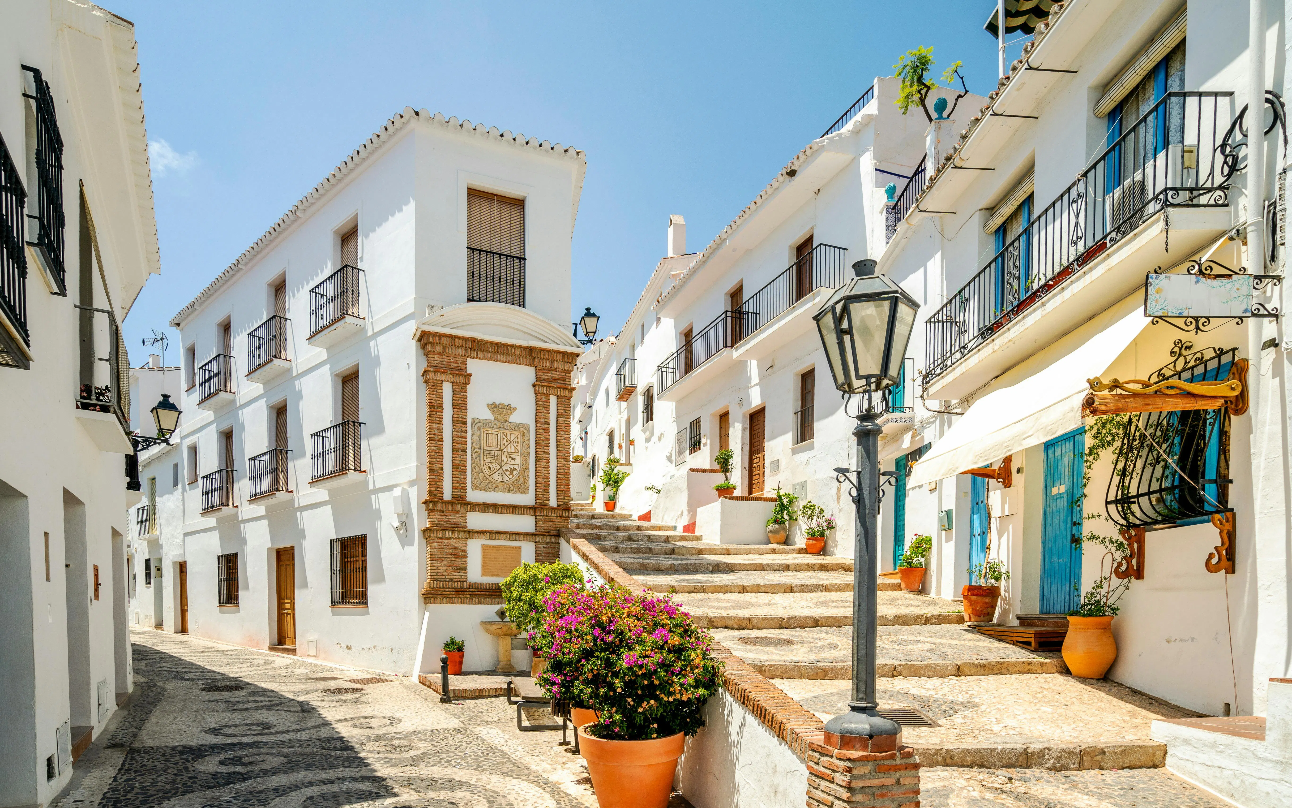 Whitewashed buildings and cobblestone street in Frigiliana, Malaga, Andalusia, Spain.