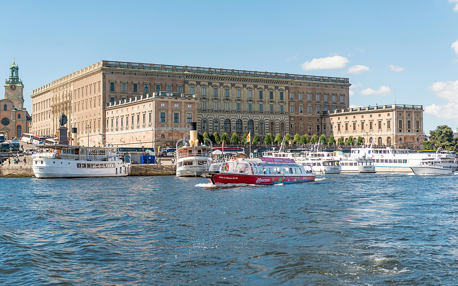 Hop-on hop-off bus in Stockholm near historic buildings, REDSIGHTSEEING tour.