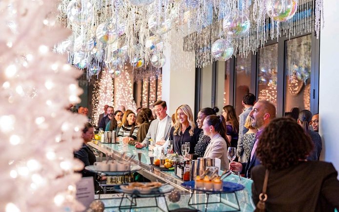 Guests enjoying drinks at the winter-themed bar in View Boston, with festive decorations and lights.