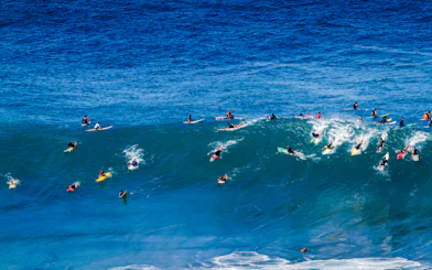 Surfers riding waves at Waimea Bay on Oahu's North Shore, Hawaii.