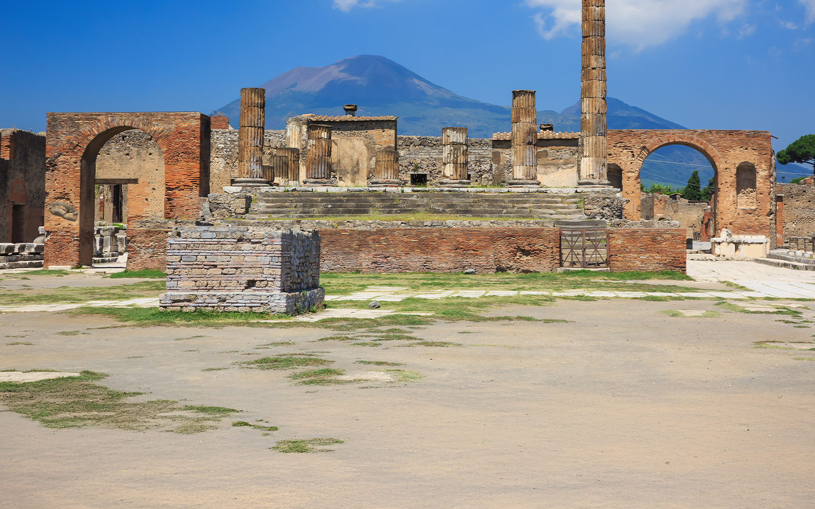 Ancient ruins of Pompeii with Mount Vesuvius in the background.