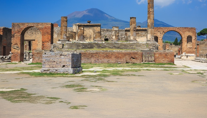 Ancient ruins of Pompeii with Mount Vesuvius in the background.