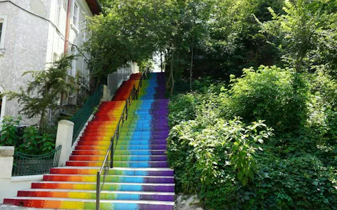 Rainbow-painted stairs surrounded by greenery in Cotroceni, Bucharest.