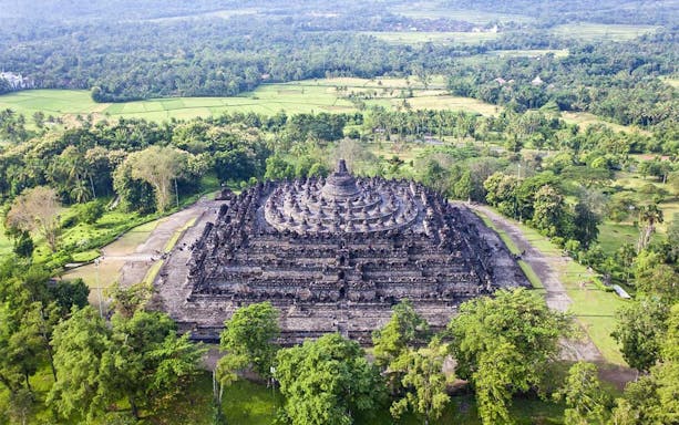 Borobudur Temple surrounded by lush greenery, part of Setumbu Sunrise tour in Indonesia.