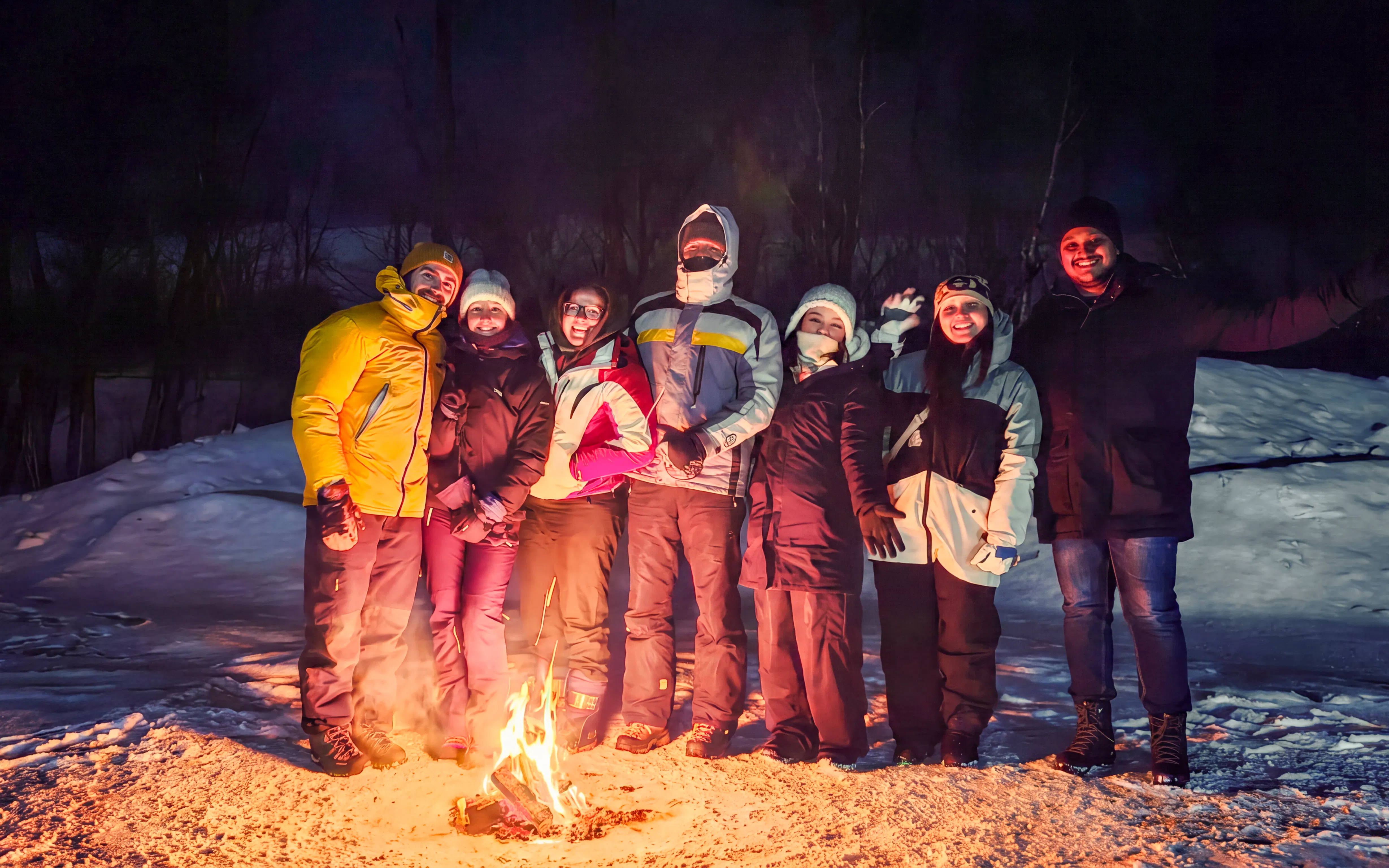 Group gathered around a campfire during a northern lights tour in Kiruna.