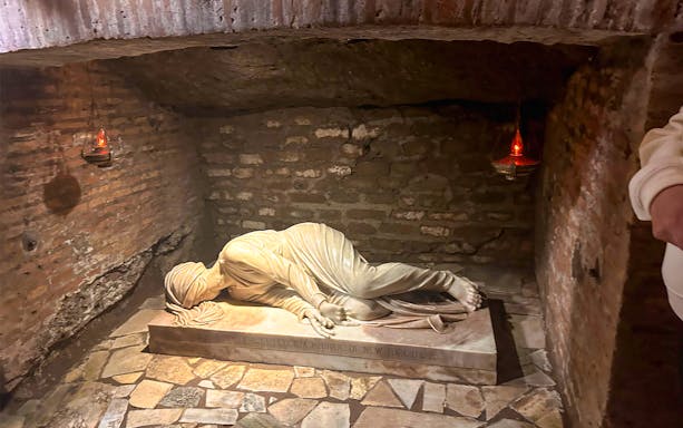 Statue of a reclining figure in a Roman crypt, part of the Christian Relics and Holy Sites in Rome tour.