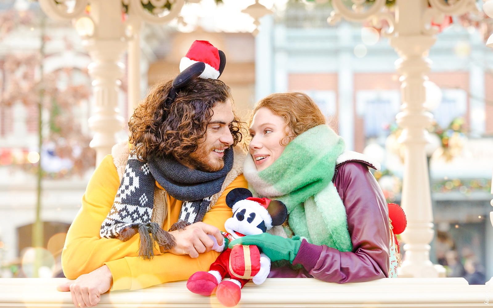 Couple enjoying Disneyland Christmas 2025 with Mickey Mouse plush.