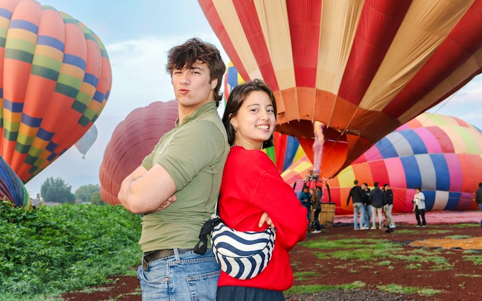 Hot air balloons preparing for flight at Teotihuacán with tourists in the foreground.