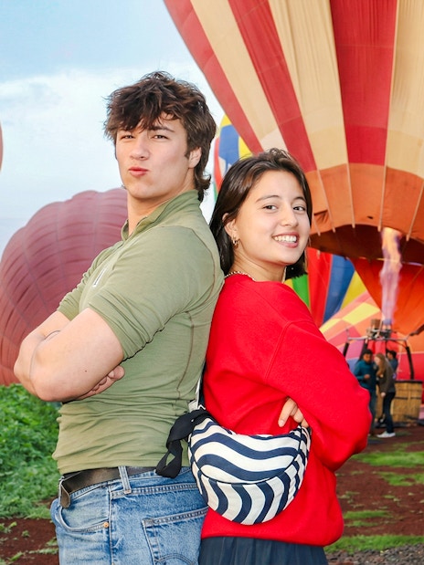 Hot air balloons preparing for flight at Teotihuacán with tourists in the foreground.