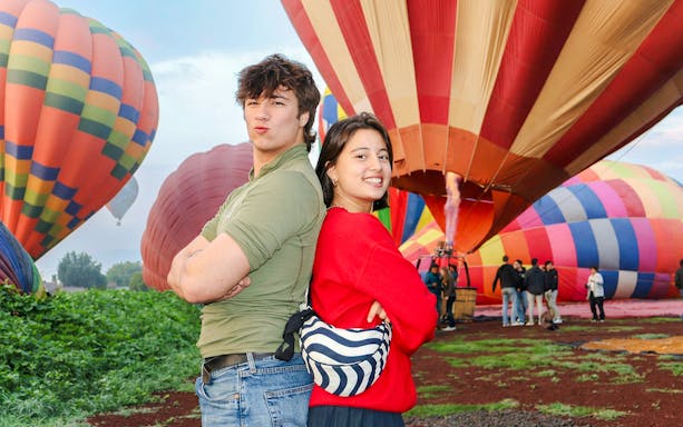 Hot air balloons preparing for flight at Teotihuacán with tourists in the foreground.
