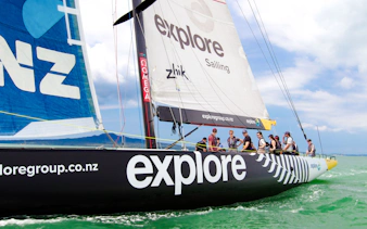 Sailing yacht with crew on Auckland's Waitemata Harbour during America's Cup experience.