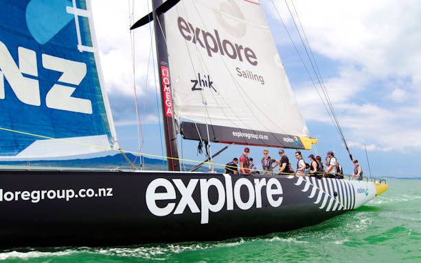Sailing yacht with crew on Auckland's Waitemata Harbour during America's Cup experience.