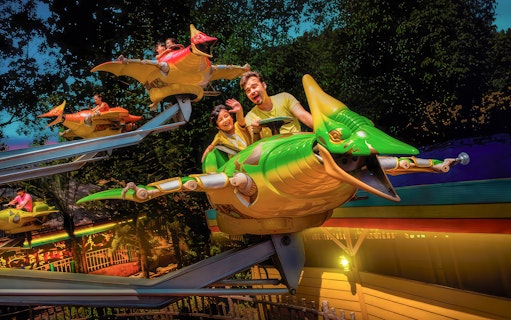 Riders enjoying a dinosaur-themed ride at Sunway Lagoon's Christmas Night Park.
