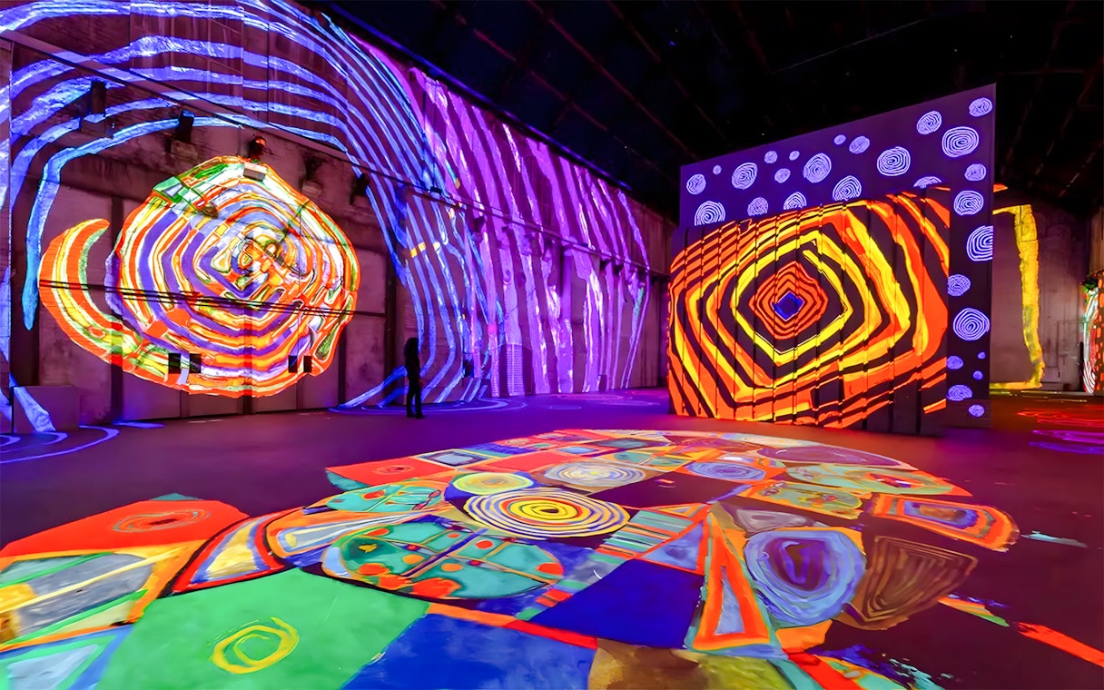 Hundertwasser Exhibit with vibrant projections at Port des Lumières, Hamburg.