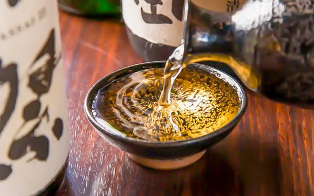 Pouring sake into a traditional Japanese cup.