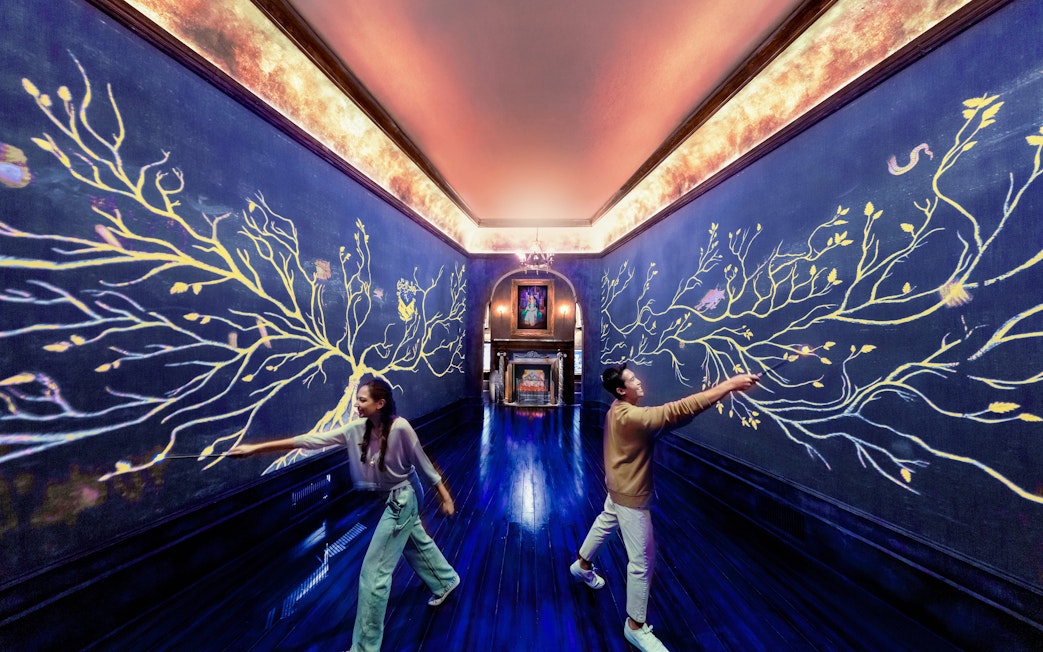 Visitors interact with magical wall art at Harry Potter Visions of Magic exhibit.