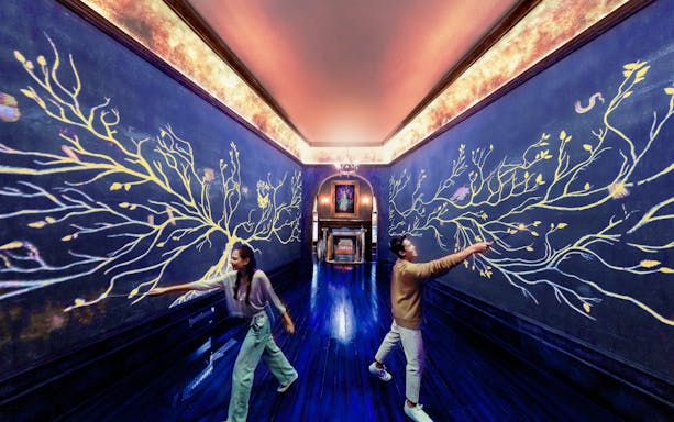 Visitors interact with magical wall art at Harry Potter Visions of Magic exhibit.