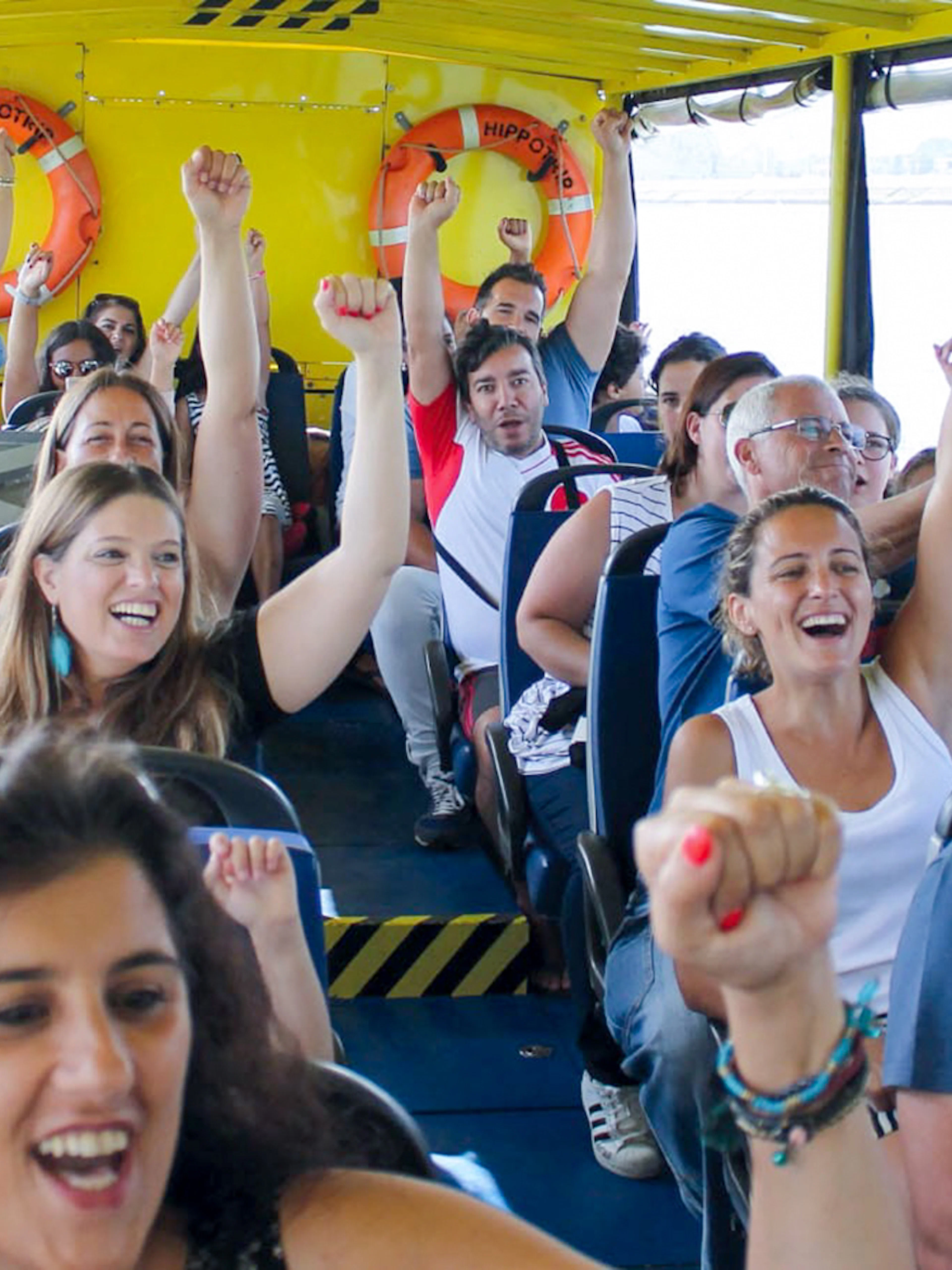 Tourists enjoying a lively boat ride on a Lisbon sightseeing guided tour.