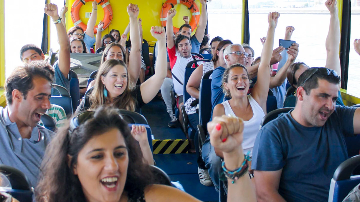 Tourists enjoying a lively boat ride on a Lisbon sightseeing guided tour.