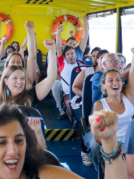 Tourists enjoying a lively boat ride on a Lisbon sightseeing guided tour.