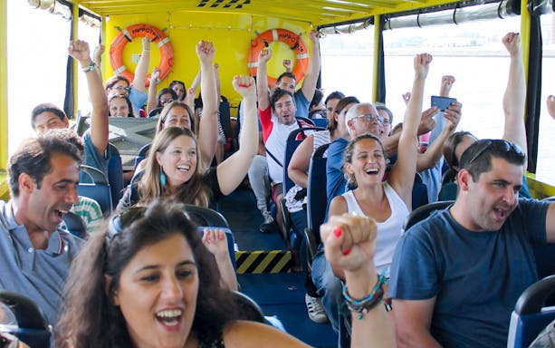 Tourists enjoying a lively boat ride on a Lisbon sightseeing guided tour.