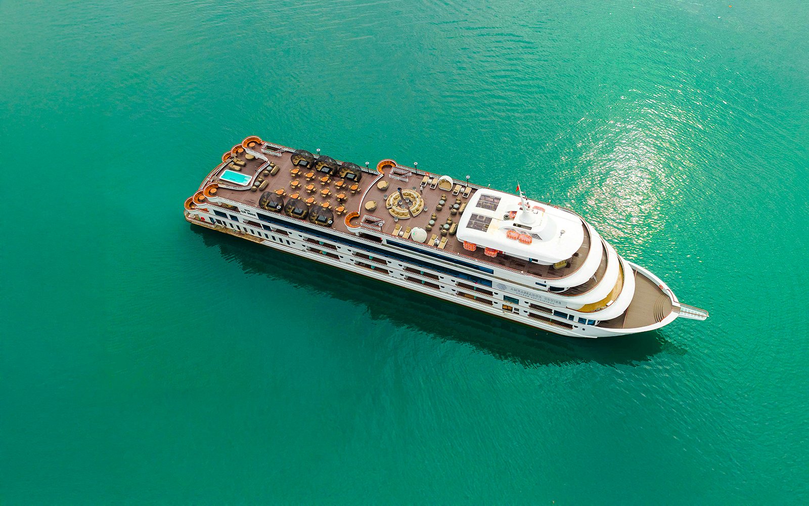 Aerial view of Ambassador cruise ship deck with pool and seating area.