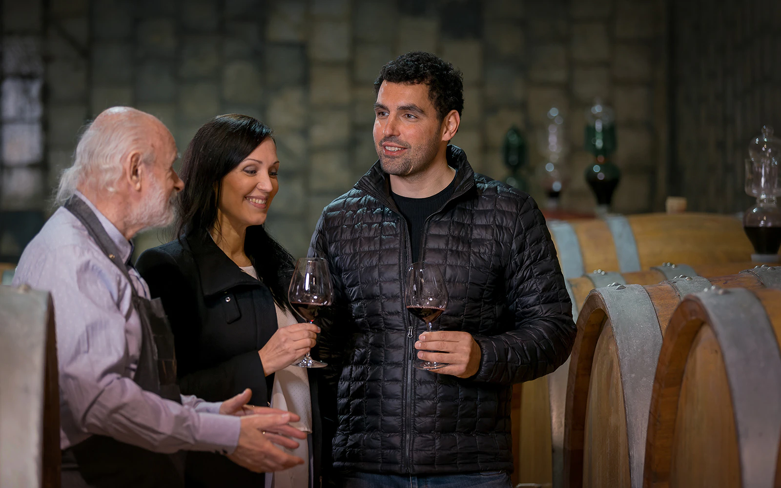 Winery guide discussing wine with visitors during a private tour.