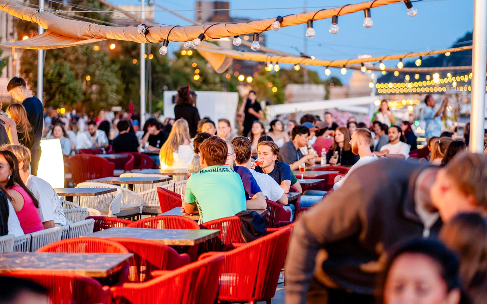 Guests enjoying drinks on Budapest Danube River nighttime cruise.