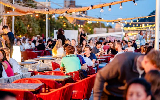 Guests enjoying drinks on Budapest Danube River nighttime cruise.