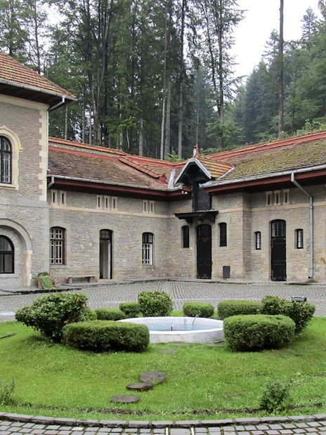 Courtyard view inside Cantacuzino Palace with stone buildings and central garden.