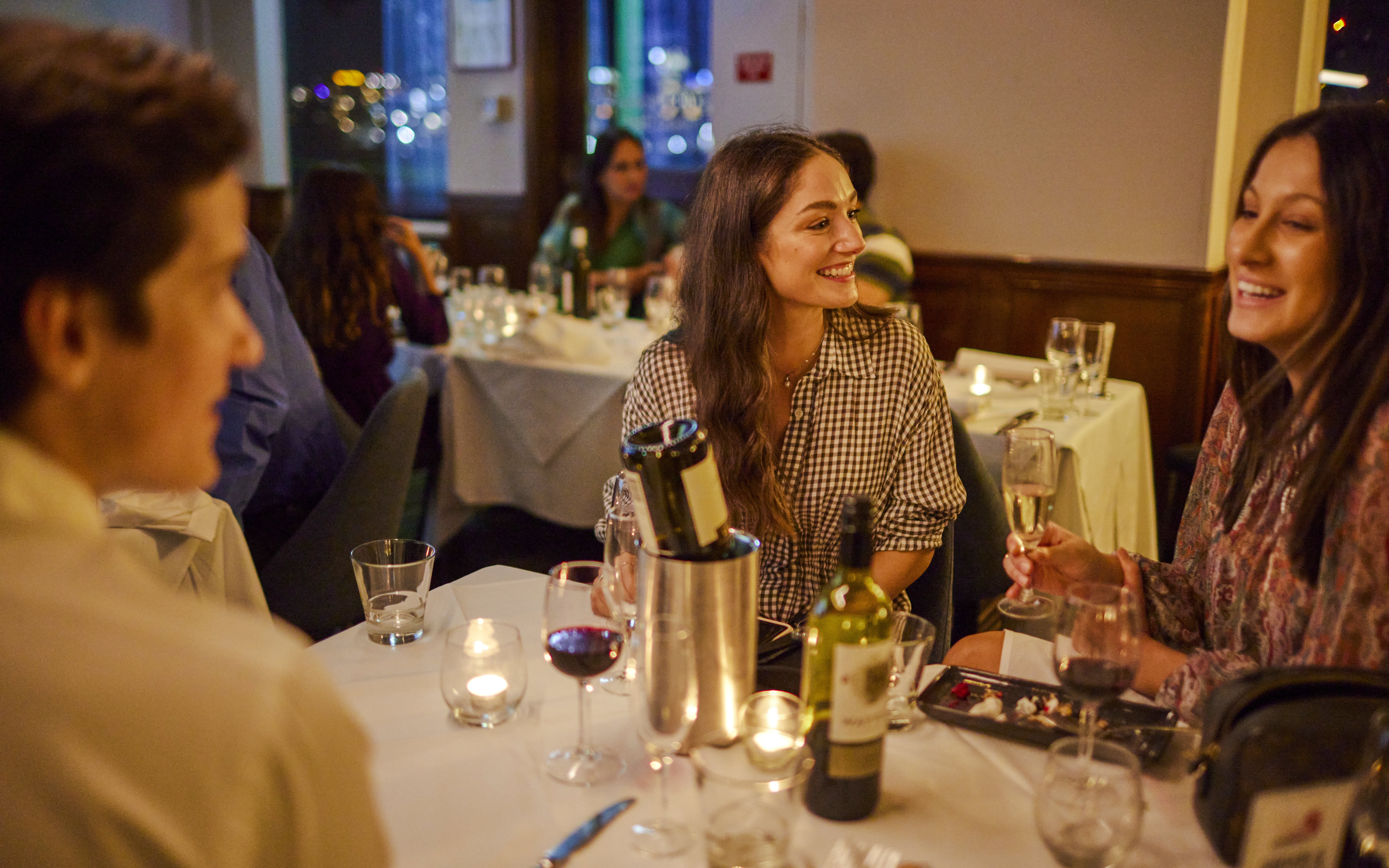 Guests enjoying dinner and drinks on the Showboat Vivid Sydney cruise with live cabaret.