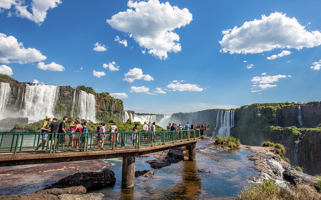 Tourists on a walkway overlooking Iguazu Falls, border of Brazil and Argentina.