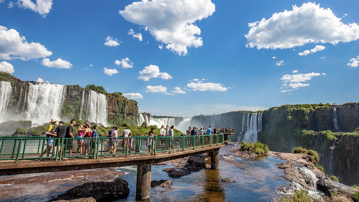 Tourists on a walkway overlooking Iguazu Falls, border of Brazil and Argentina.