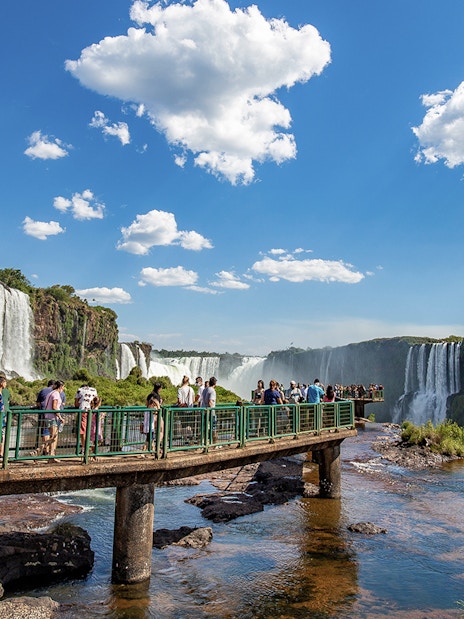 Tourists on a walkway overlooking Iguazu Falls, border of Brazil and Argentina.