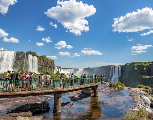 Iguazu Falls cascading between Brazil and Argentina, lush greenery surrounding the waterfalls.
