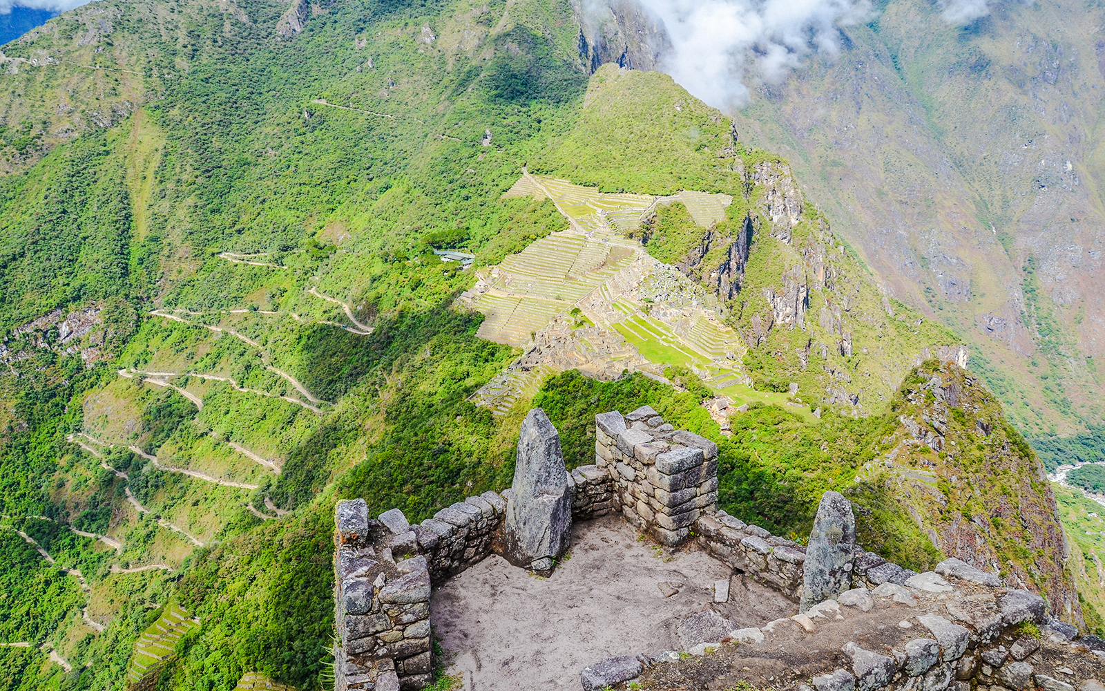 Panoramic view of Machu Picchu terraces and mountains from Huayna Picchu summit.