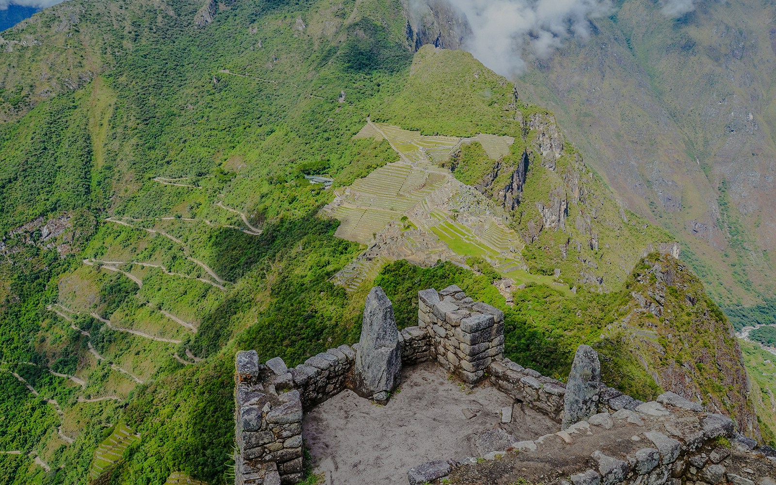 Panoramic view of Machu Picchu terraces and mountains from Huayna Picchu summit.